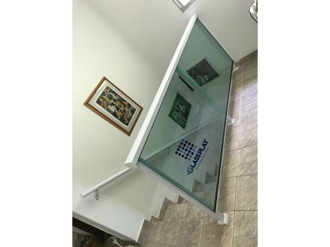 Corrimão de escada com esquadrias de alumínio branco e vidro verde